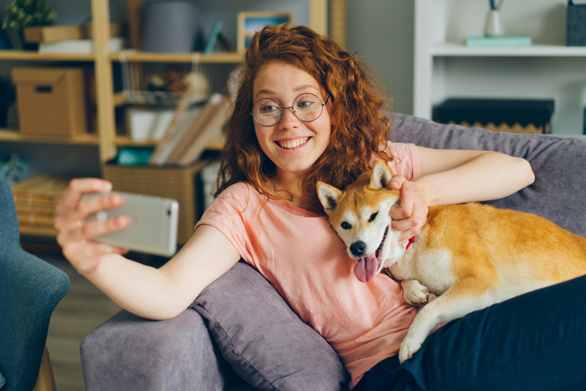 Woman taking a selfie with her Shiba Inu on the couch